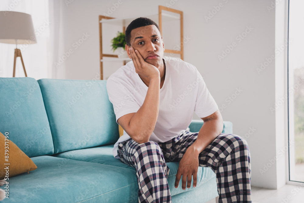 Photo of bored funny guy sleepwear pajama staying home sofa indoors house apartment room Photo of bored funny guy sleepwear pajama staying home sofa indoors house apartment room