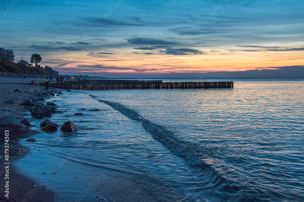 View of sand beach with wooden breakwaters on the Baltic Sea coast on sunset in Zelenogradsk. Russia