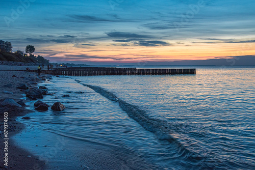 Obraz na płótnie View of sand beach with wooden breakwaters on the Baltic Sea coast on sunset in Zelenogradsk. Russia w salonie