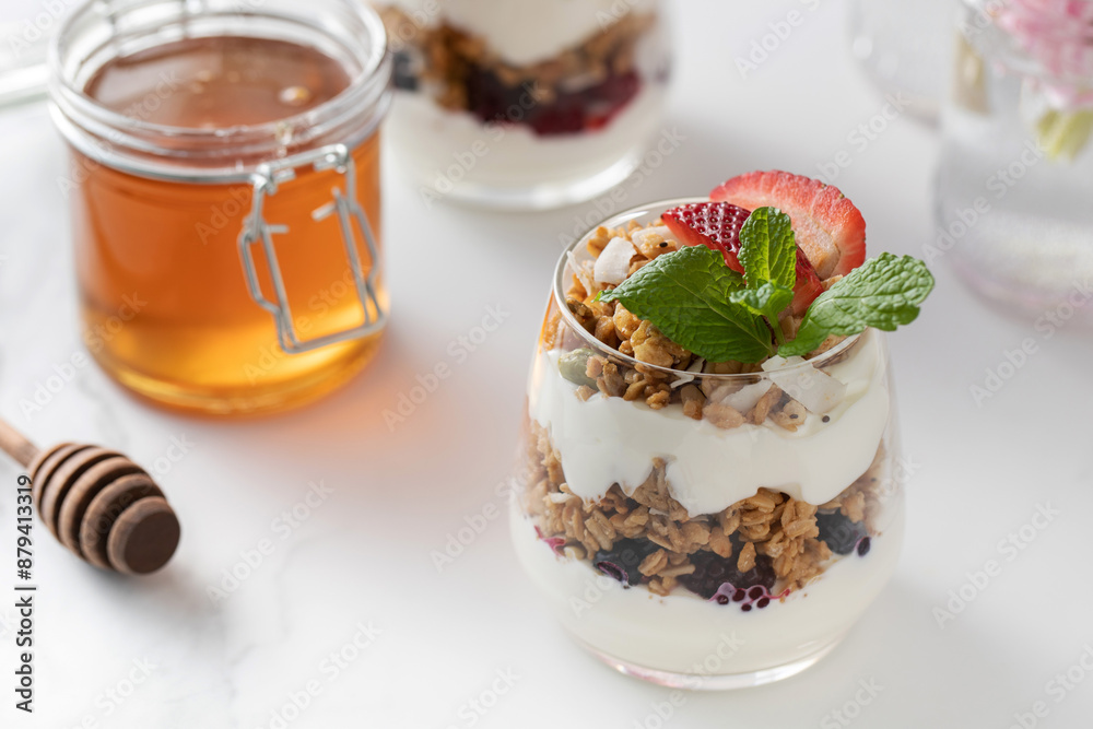 Yogurt with crispy granola, berries and honey for a delicious breakfast. Healthy eating. Yogurt with crispy granola, berries and honey for a delicious breakfast. Healthy eating.