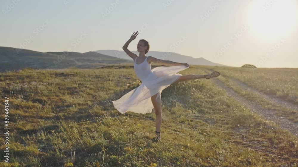 An attractive young woman in a white dress dances under the bright summer sun at sunset and smiles against the backdrop of a mountain range. Instagram. Social media. Slow motion