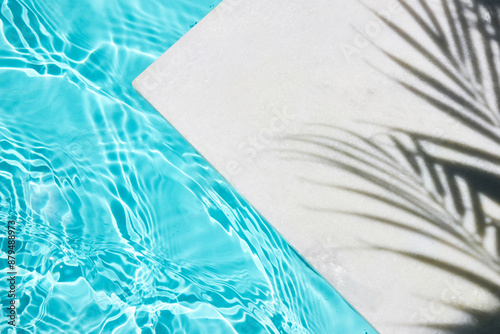 Wallpaper Mural Poolside Serenity. Shadow of a palm tree on a white surface next to a clear blue swimming pool. Torontodigital.ca