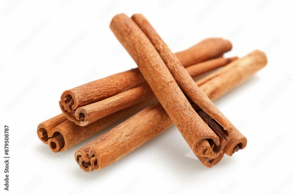 Cinnamon sticks forming a cross shape, laying on each other on a white background Cinnamon sticks forming a cross shape, laying on each other on a white background