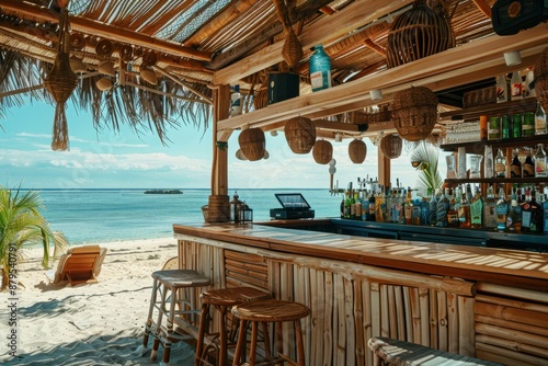 A beautiful beachside bar with wooden stools and a variety of alcoholic beverages on display. The clear blue sky and tranquil ocean in the background add to the relaxing atmosphere.