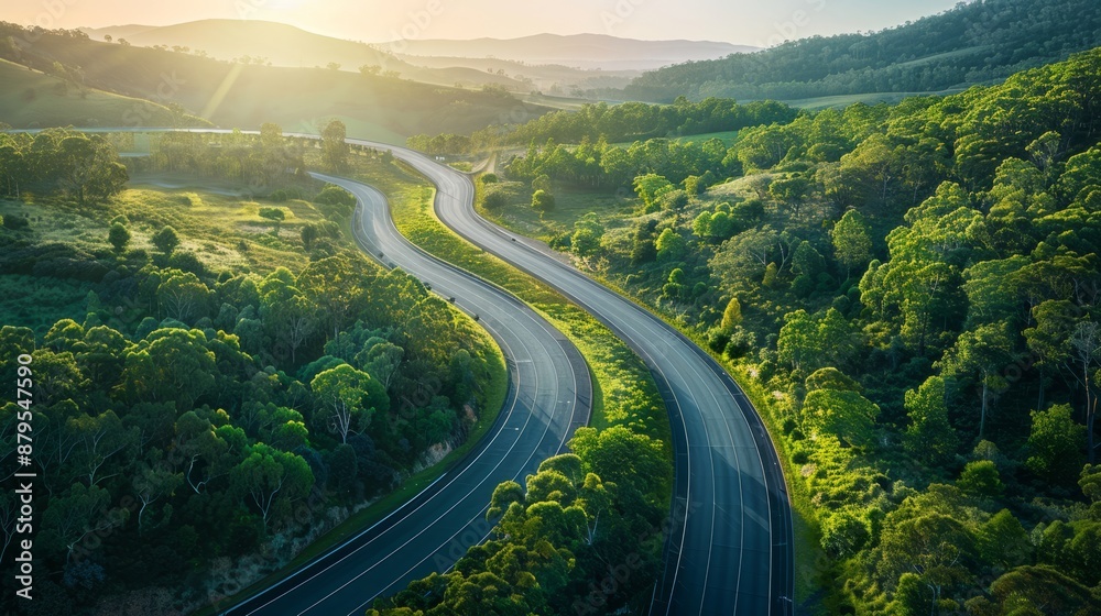 Curving highway through lush green landscape at sunset Curving highway through lush green landscape at sunset