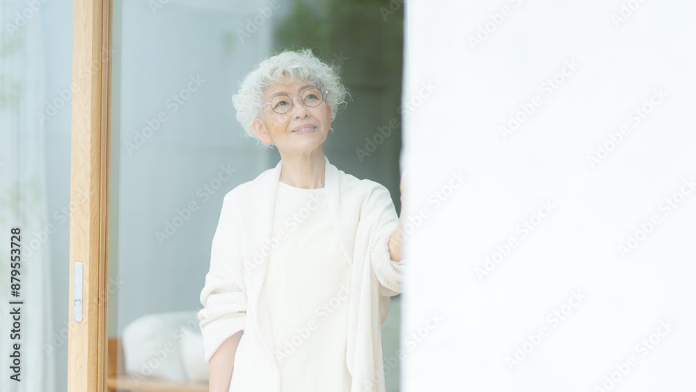 窓の外を眺めるシルバーヘアの女性 窓の外を眺めるシルバーヘアの女性