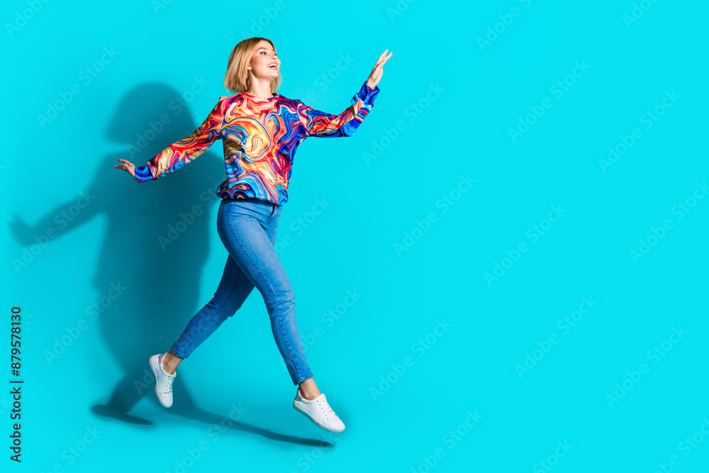 Full size photo of optimistic adorable girl dressed print shirt jeans look at discount empty space isolated on blue color background Full size photo of optimistic adorable girl dressed print shirt jeans look at discount empty space isolated on blue color background