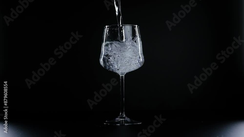 water is poured into a glass on a black background