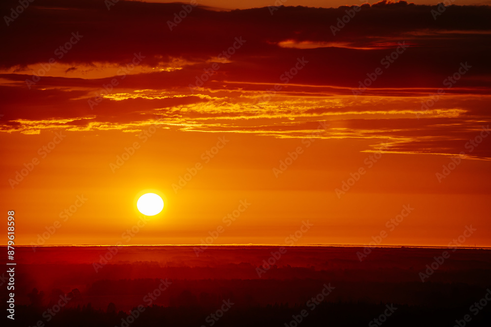 A radiant sunset over a forested horizon, with the sun casting a warm, golden glow across the sky and landscape. The vibrant orange and yellow hues create a stunning and tranquil scene. Copy space. A radiant sunset over a forested horizon, with the sun casting a warm, golden glow across the sky and landscape. The vibrant orange and yellow hues create a stunning and tranquil scene. Copy space.