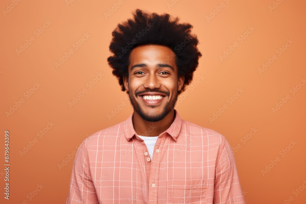 Portrait of a cheerful afro-american man in his 20s dressed in a relaxed flannel shirt in solid color backdrop Portrait of a cheerful afro-american man in his 20s dressed in a relaxed flannel shirt in solid color backdrop
