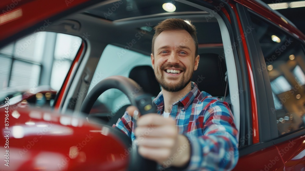 Happy man sits in new car in shop dealership and celebrate purchase of new vehicle. The man with keys shows emotions of happiness while driving in her new car. Happy man sits in new car in shop dealership and celebrate purchase of new vehicle. The man with keys shows emotions of happiness while driving in her new car.