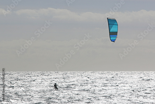 Kitesurfer riding his board in waves