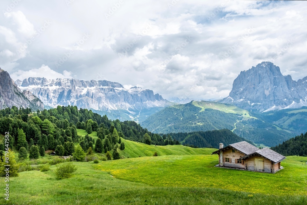 Fototapeta premium Seiser Alm - Wanderparadies in den Südtiroler Dolomiten. Saftig grüne Wiesen mit urigen Hütten umringt vor schroffen Berggipfeln auf der größten Hochalm Europas.
