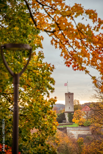 Die Bielefelder Sparrenburg im goldenen Herbst zu Sonnenaufgang durch bunte Blätter fotografiert.