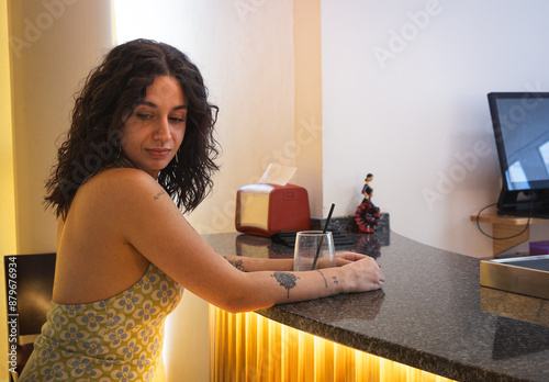 young woman has a drink at the hotel bar after teleworking. photo