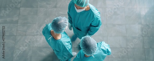 Three surgeons in scrubs stand together in a medical setting.