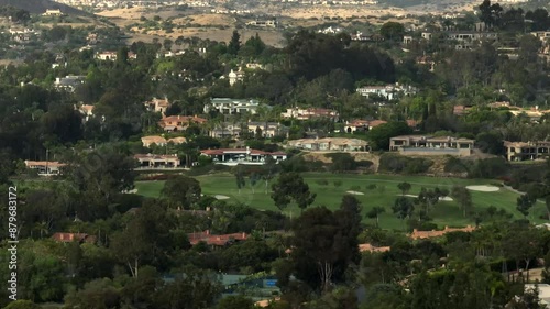 Aerial view of golf course in Rancho Santa Fe San Diego California with luxury homes and lush greens trees and water surrounding  photo