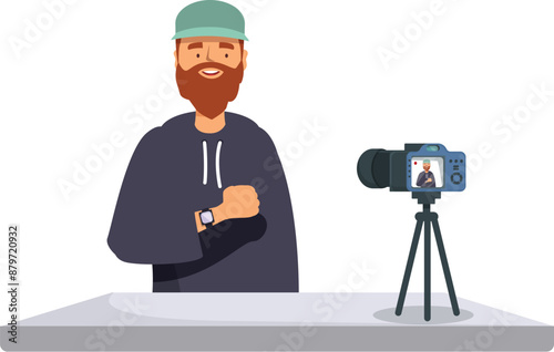 Bearded man in hoodie recording a vlog using a camera on a tripod