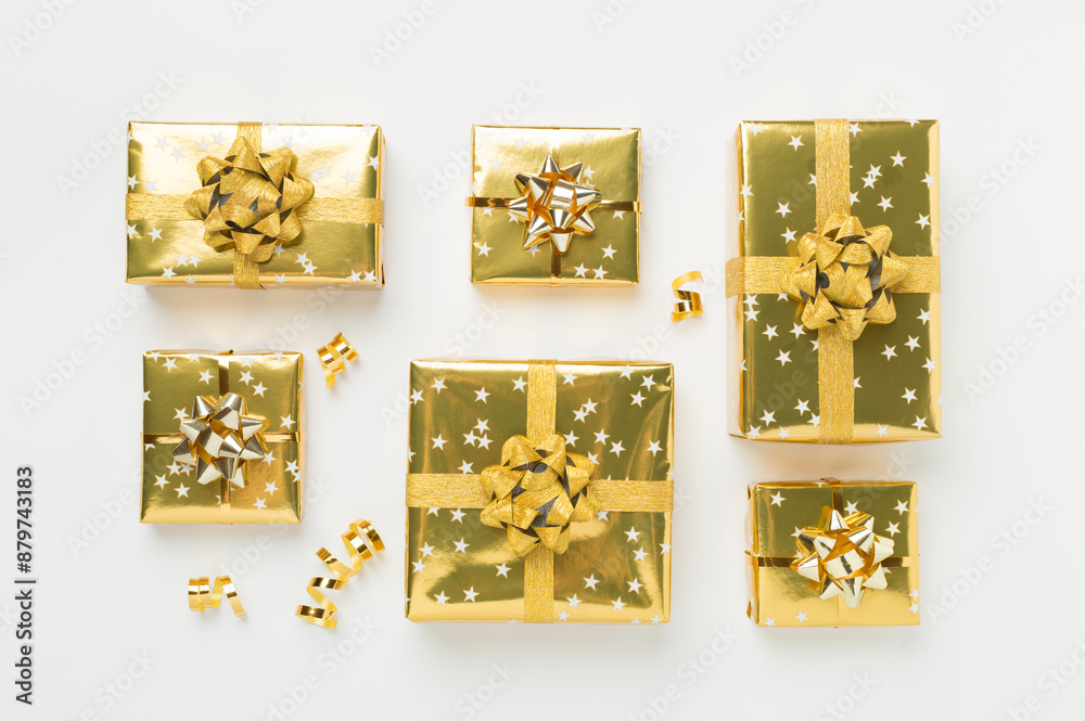 Obraz premium Golden gift boxes and confetti on color background, top view