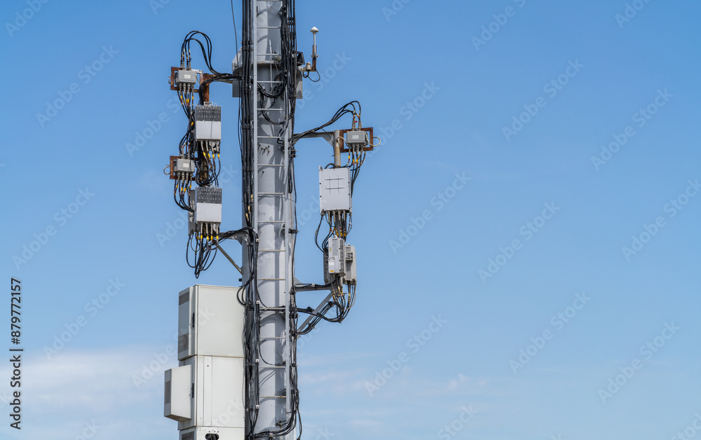 Telecommunications hub equipment, remote radio unit RRU, uninterruptible power source, cable entry for optical cables. Cell tower with new telecommunications and 4G and 5G wireless equipment. Telecommunications hub equipment, remote radio unit RRU, uninterruptible power source, cable entry for optical cables. Cell tower with new telecommunications and 4G and 5G wireless equipment.