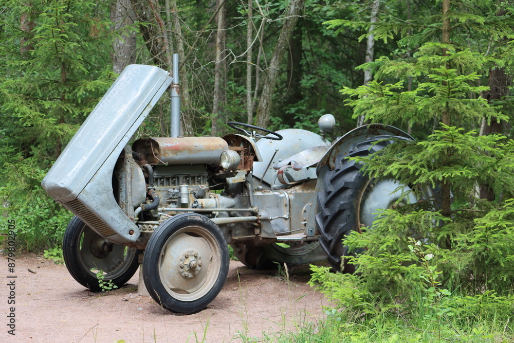 Sweden. An old tractor stands in the forest. Östergötland province. Sweden. An old tractor stands in the forest. Östergötland province.