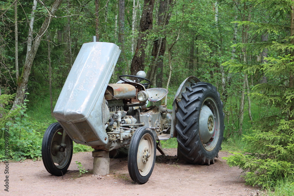 Sweden. An old tractor stands in the forest. Östergötland province. Sweden. An old tractor stands in the forest. Östergötland province.