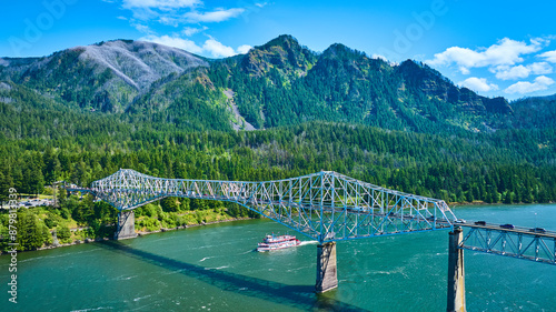 Aerial of Bridge of the Gods Over River with Paddle Steamer in Forested Mountains