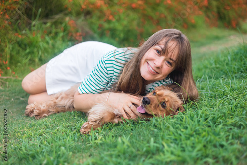 cocker Spaniel dog having fun and playing with young beautiful woman photo