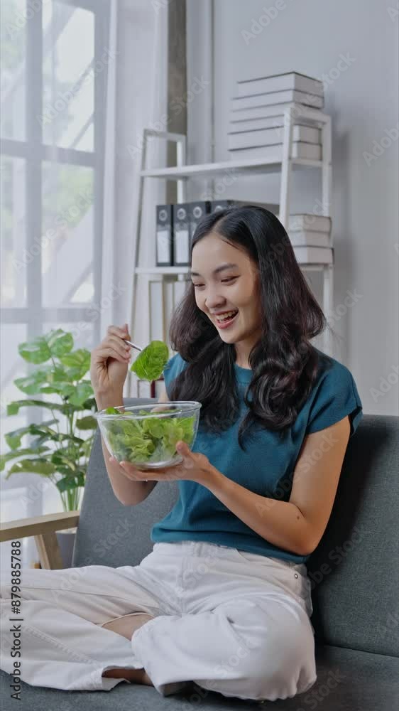 Young woman enjoys a healthy salad by the window in slow motion. Embracing wellness and healthy eating habits in a cozy indoor setting Young woman enjoys a healthy salad by the window in slow motion. Embracing wellness and healthy eating habits in a cozy indoor setting