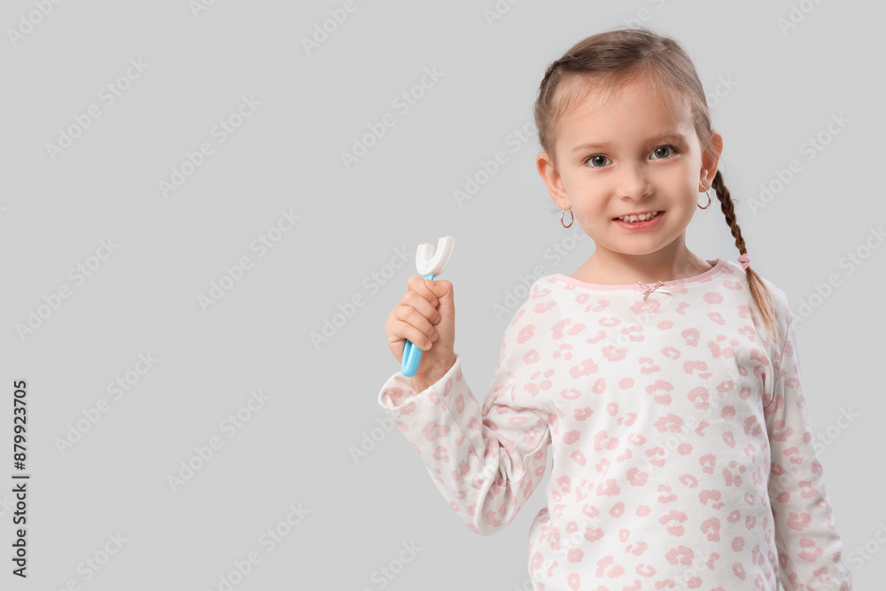 Happy little girl with toothbrush on grey background Happy little girl with toothbrush on grey background