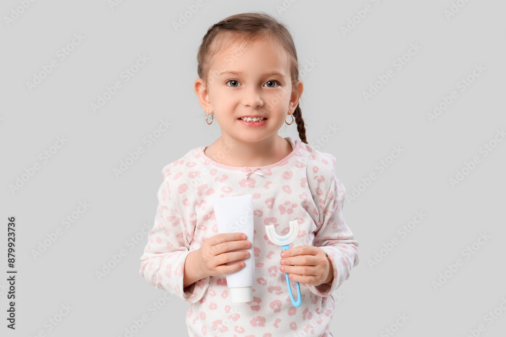 Happy little girl with brush and toothpaste on grey background Happy little girl with brush and toothpaste on grey background