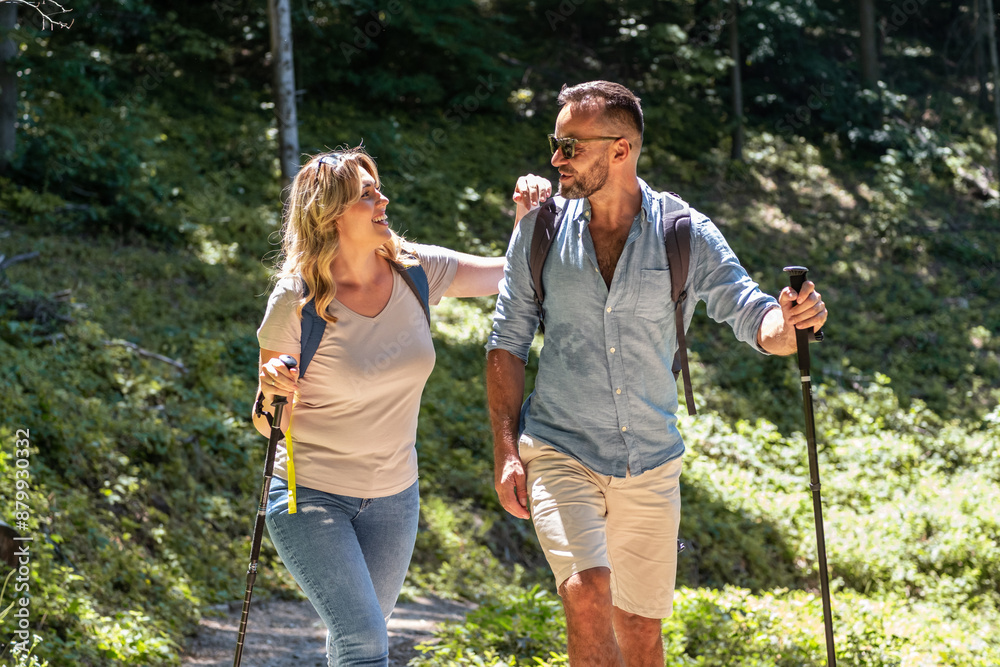 A couple enjoys hiking together in nature on a sunny summer day. They walk along a trail, taking in the beautiful surroundings and sharing smiles and laughter. A couple enjoys hiking together in nature on a sunny summer day. They walk along a trail, taking in the beautiful surroundings and sharing smiles and laughter.