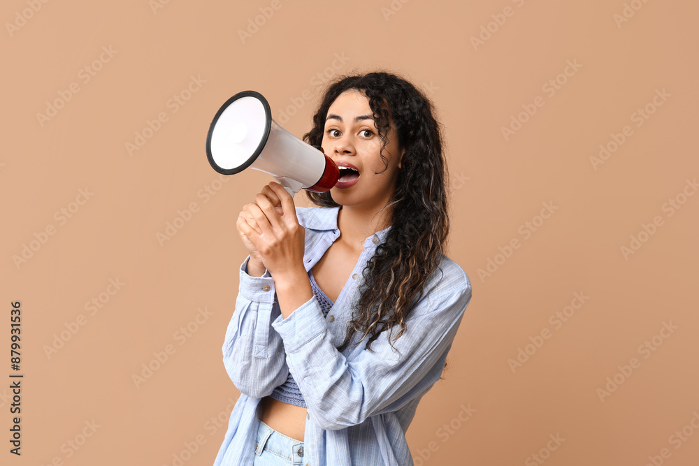 Young African-American woman with megaphone on beige background Young African-American woman with megaphone on beige background