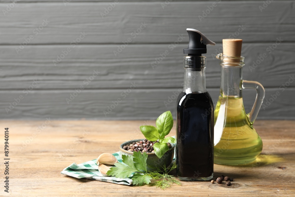 Bottle of balsamic vinegar, oil and other products on wooden table, space for text Bottle of balsamic vinegar, oil and other products on wooden table, space for text