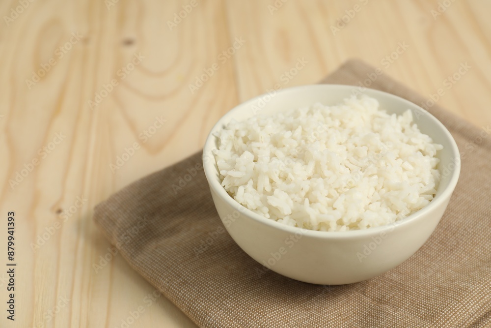Delicious boiled rice in bowl on wooden table Delicious boiled rice in bowl on wooden table