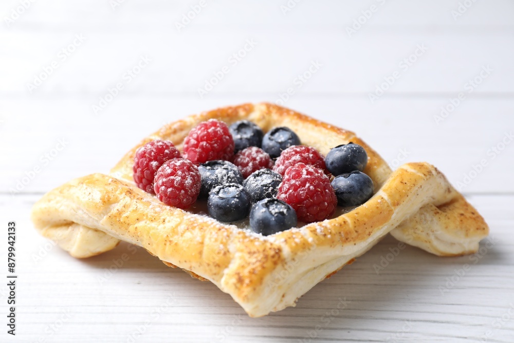 Tasty puff pastry with berries on white wooden table, closeup Tasty puff pastry with berries on white wooden table, closeup