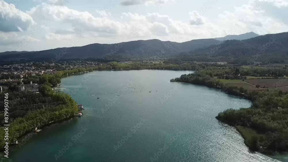 Aerial shot of lake near city and mountains on sunny dayLake of Banyoles, Spain Aerial shot of lake near city and mountains on sunny dayLake of Banyoles, Spain