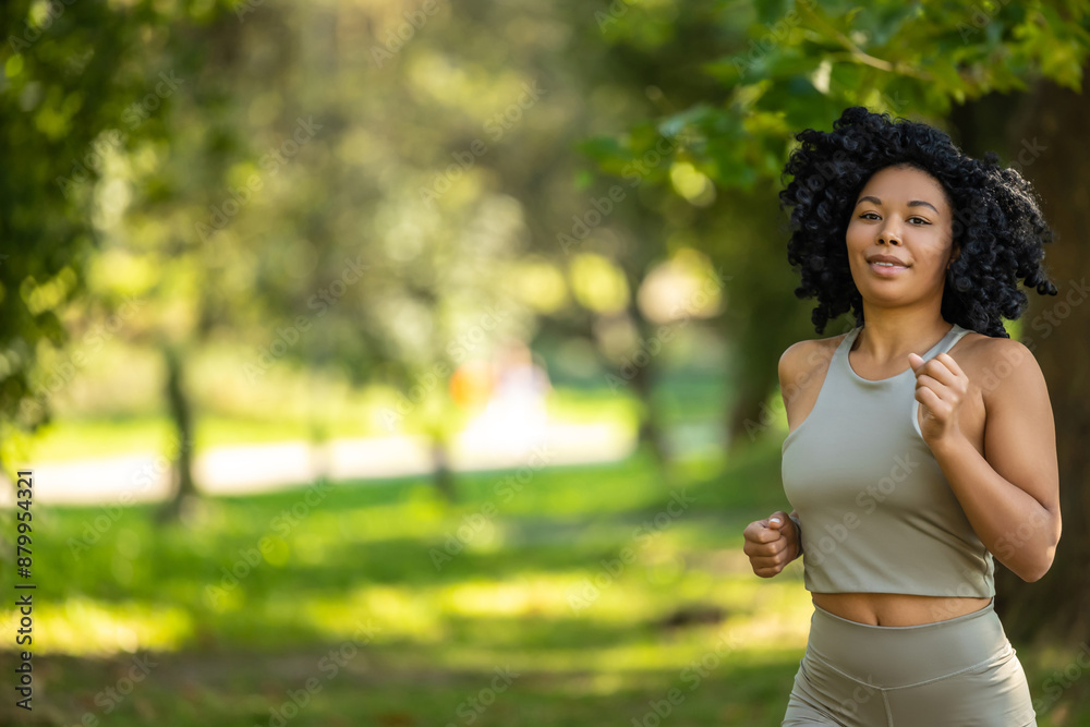 Brunette woman running in a park and looking focused Brunette woman running in a park and looking focused