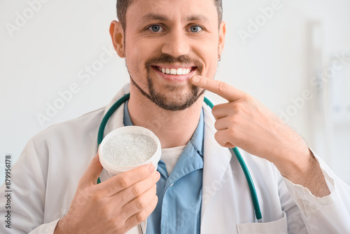 Male dentist with powder po...