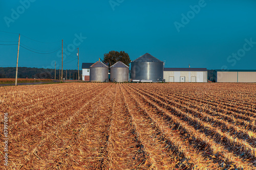 фотографія Harvested Corn Field with Grain Bins