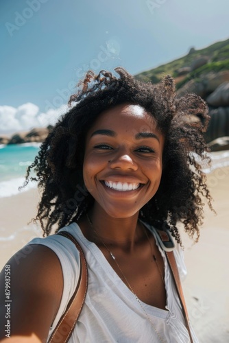 A woman stands alone on a beach with the ocean waves in the background