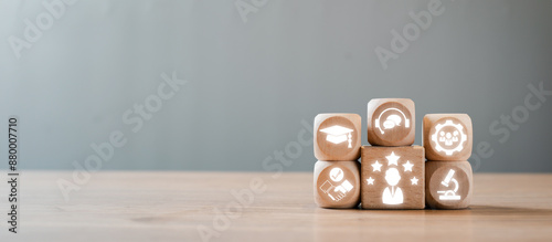 Bild auf Leinwand Wooden blocks with icons symbolizing different expertise concepts, arranged on a wooden table against a grey background