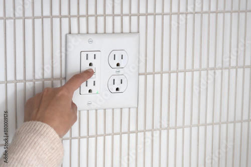 Pressing reset button on a GFCI outlet. Resetting GFCI outlet