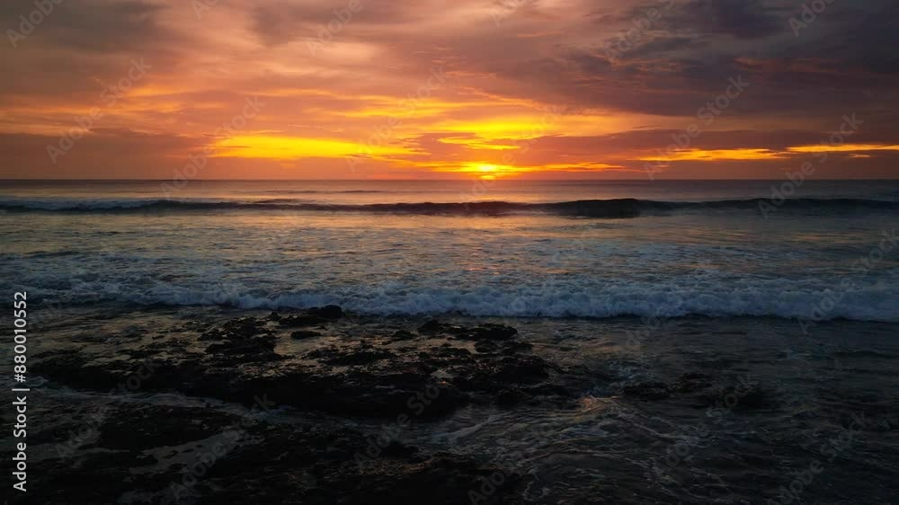 Vibrant colorful sunset over ocean with waves on exotic beach Vibrant colorful sunset over ocean with waves on exotic beach