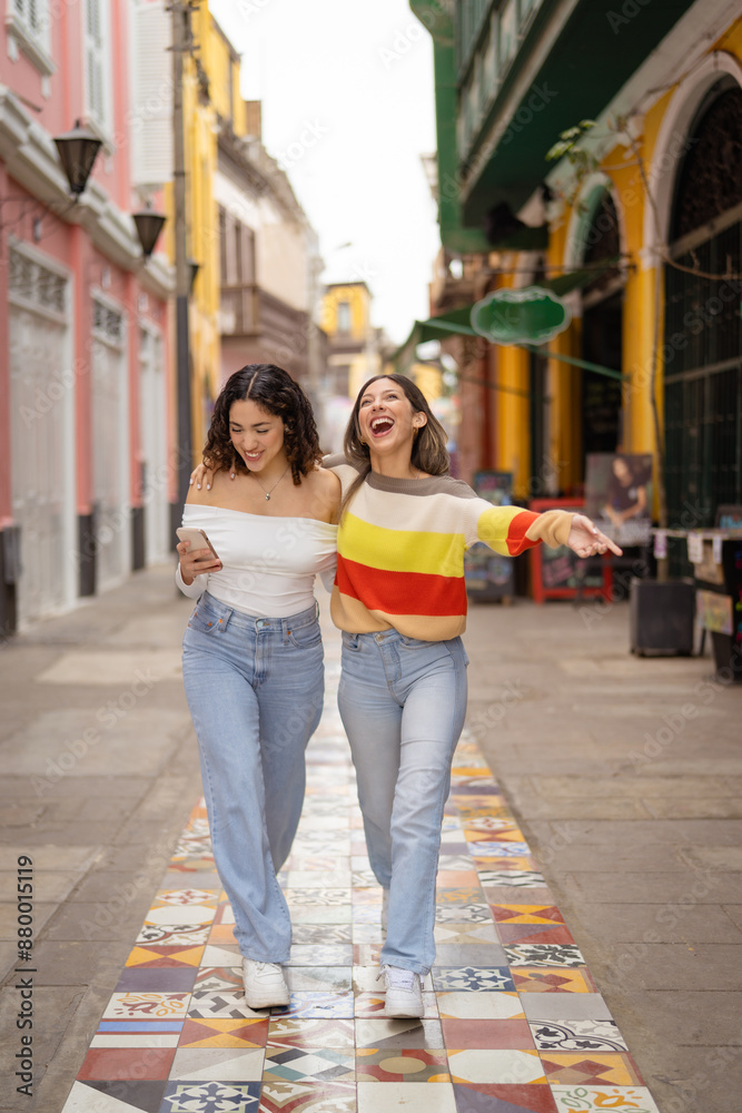 Two friends enjoying a day together walking down a colorful street