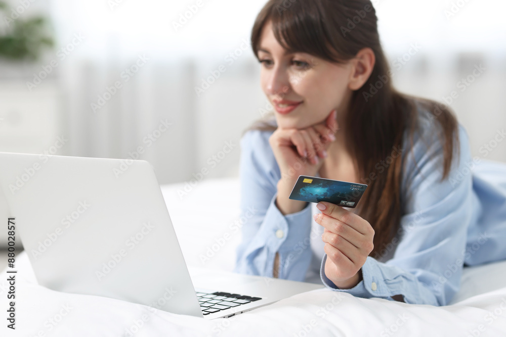 Online banking. Smiling woman with credit card and laptop paying purchase at home, selective focus Online banking. Smiling woman with credit card and laptop paying purchase at home, selective focus