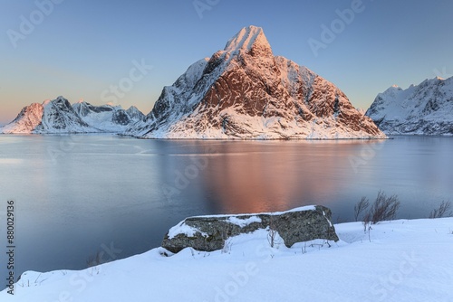 Snow-covered mountains reflected in the fjord at sunrise, winter, Reine, Moskenesoya, Lofoten, Norway, Europe