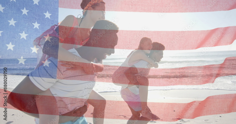 Naklejka premium Image of flag of usa over happy diverse men carrying women piggyback on beach in summer