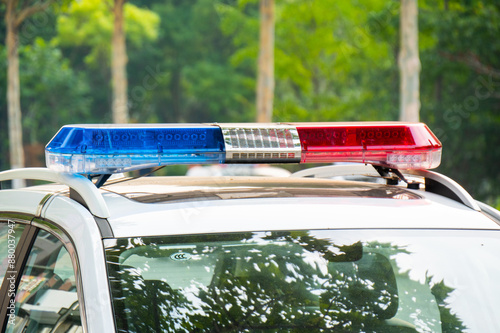 Police lights on car during traffic surveillance on the city road. Flash light on the vehicle of the Emergency Services. Red and blue flashes on the cars of the Patrol specialized unity. 