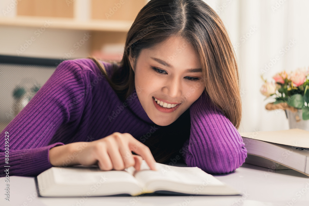 Beautiful young woman in sweater reads a book on table in the living room, relax at home. Beautiful young woman in sweater reads a book on table in the living room, relax at home.
